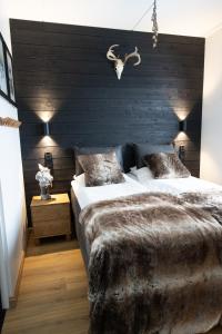 a bedroom with a large bed with a black wall at Levi Cranberry in Sirkka