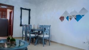 a dining room with a blue table and chairs at Condominio Paseo del Mar in La Francia