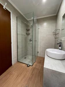 a bathroom with a glass shower and a white tub at Spyros Apartment in Paleo Tsifliki +12 photos