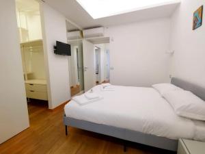 - une chambre avec un lit blanc et une télévision dans l'établissement G&G Home, à Bari