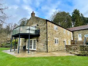 an exterior view of a brick house with a glass roof at The Barn at Rigg End in Rosedale Abbey