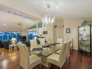 a dining room and living room with a glass table and chairs at Tranquility with views of the coast in Gold Coast