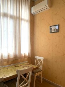 une pièce avec une table et deux chaises et une fenêtre dans l'établissement Apartment at Rustaveli avenue, near opera, à Tbilissi