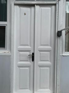- une porte blanche sur un bâtiment blanc avec une fenêtre dans l'établissement Apartment at Rustaveli avenue, near opera, à Tbilissi