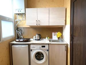 une cuisine avec une machine à laver et un évier dans l'établissement Apartment at Rustaveli avenue, near opera, à Tbilissi 4 autres photos