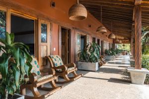 eine Veranda eines Hauses mit Stühlen und Topfpflanzen in der Unterkunft Hotel El Cielo en la Tierra in Alcalá