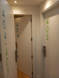 a white door with green numbers on the wall at Hotel Cangas de Onis Center in Cangas de Onís