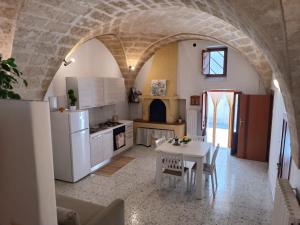 a kitchen with a white table and a kitchen with an archway at Casa Vacanze Teichos in Grottaglie