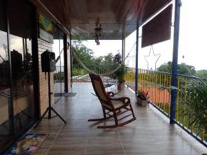 a rocking chair on a porch with a hammock at Hostal Quebrada Verde in El Colegio +9 photos