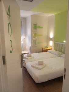 two beds in a room with a door open at Hotel Cangas de Onis Center in Cangas de Onís