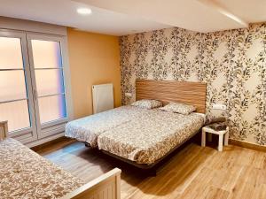 een slaapkamer met 2 bedden en een raam bij Apartamentos San Nicolás in Logroño