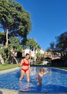 una mujer y un niño en una piscina en Apto Aldea del Coto, en Chiclana de la Frontera