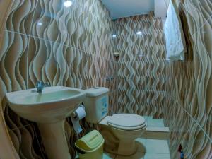 La salle de bains est pourvue d'un lavabo et de toilettes. dans l'établissement Hotel Sol de Oro Ayacucho, à Ayacucho
