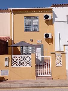 a building with a gate and an umbrella at PEP'S Family House in Empuriabrava