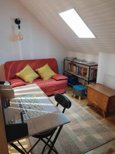 uma sala de estar com um sofá vermelho e uma mesa em Gite Au Bout du Monde 