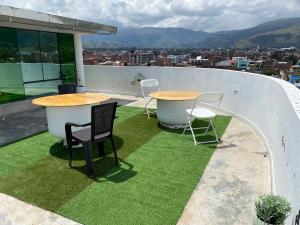 two tables and chairs on the roof of a building at Rooms MD y FS in Huancayo