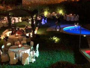 un gruppo di persone sedute intorno a una piscina di notte di Borgo Antico XIX sec. a Gesturi Altre 37 foto
