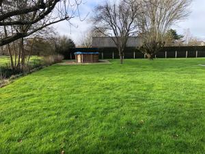un gran campo de hierba con un cubo de basura. en Le Moulin de montinault, en Mulsanne