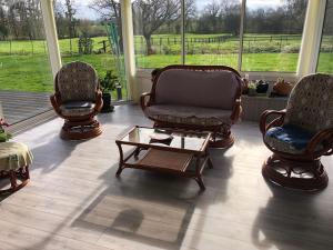 Una sala de estar con tres sillas y una mesa de café. en Le Moulin de montinault, en Mulsanne