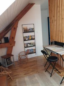 uma sala de estar com uma mesa e cadeiras e uma escadaria em Gite Au Bout du Monde 