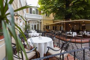 un ristorante all'aperto con tavoli, sedie e ombrelloni di Residence Odesskij Dvorik a Odessa