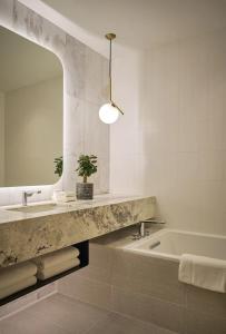 a bathroom with a sink and a tub and a mirror at The Loren at Lady Bird Lake in Austin