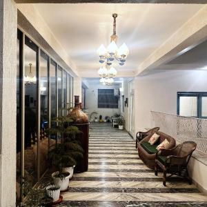 uma sala de estar com um sofá e um lustre em Tringrahi Vraj Mahal em Vrindavan