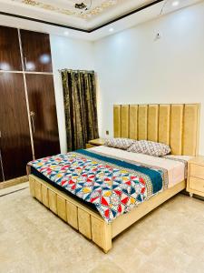um quarto com uma cama com uma colcha colorida em Golden Plaza em Gujrānwāla
