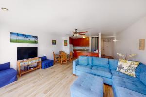 a living room with a blue couch and a table at Turtle Bay Resort 166 in Kahuku