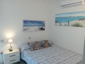 PEP'S Family House في إمبوريابرافا: غرفة نوم بسرير وصورة للشاطئ