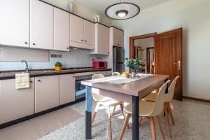 a kitchen with white cabinets and a table and chairs at Sweet Home Graziella vicino stazione Bologna per 6 persone in Bologna +29 photos