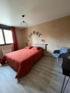 - une chambre avec un grand lit rouge et un bureau dans l'établissement Le Panoramique, Calme - Spacieux, à Châteauroux-les-Alpes