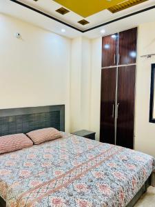 - une chambre avec un grand lit et une armoire en bois dans l'établissement Golden Plaza, à Gujrānwāla