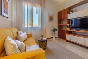 a living room with a yellow couch and a television at Sweet Home Graziella vicino stazione Bologna per 6 persone in Bologna
