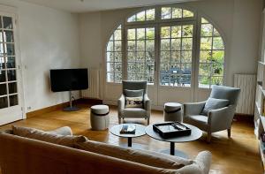 拉波勒的住宿－Maison de famille La Baule les pins，客厅配有沙发、椅子和电视