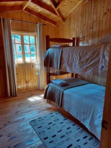 a bedroom with two bunk beds in a cabin at Cabaña Queltehue Cochamó in Cochamó