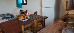 a kitchen with a table with a bowl of fruit on it at VENOS APARTMENTS in Marmari