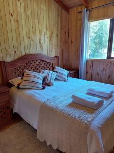 una camera da letto con un letto e due asciugamani di Cabaña Queltehue Cochamó a Cochamó