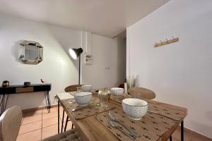 a dining room with a wooden table with bowls at The Théolier Duplex in Tournon-sur-Rhône