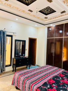 1 dormitorio con cama y piano en Golden Plaza, en Gujrānwāla