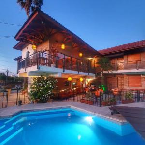 una casa con piscina frente a un edificio en Hotel Carlos Paz en Villa Carlos Paz