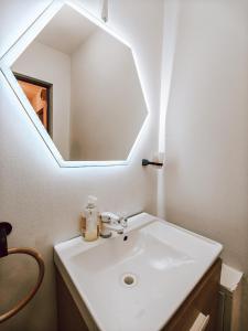 een badkamer met een witte wastafel en een spiegel bij Charming City Hideout in Cluj-Napoca