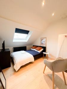 1 dormitorio en el ático con cama y ventana en Cozy Bed and Breakfast at European Commision en Bruselas