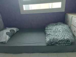 a bed with two pillows on it with a window at Logement avec parking à 11 min de Paris et 15 min de la défense Arena in Argenteuil