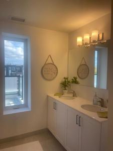 een badkamer met een wastafel, een spiegel en een raam bij Deluxe Place on Kawartha Lakes in Fenelon Falls