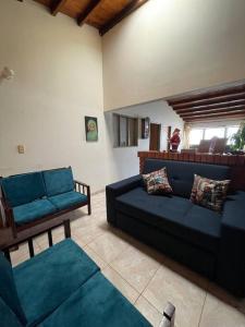 un soggiorno con divano blu e sedie di Villa Concha a Villanueva