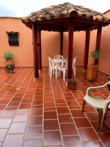 patio con sedie bianche e gazebo in legno di Villa Concha a Villanueva