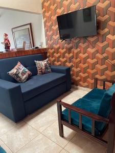 un soggiorno con divano blu e TV a schermo piatto di Villa Concha a Villanueva