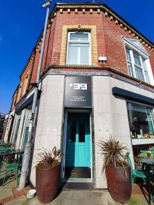 a brick building with a blue door on a street at Sgwâr in Menai Bridge