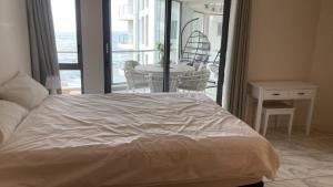 a bedroom with a bed and a table and a balcony at Hibernian 10.02 in Cape Town +13 photos